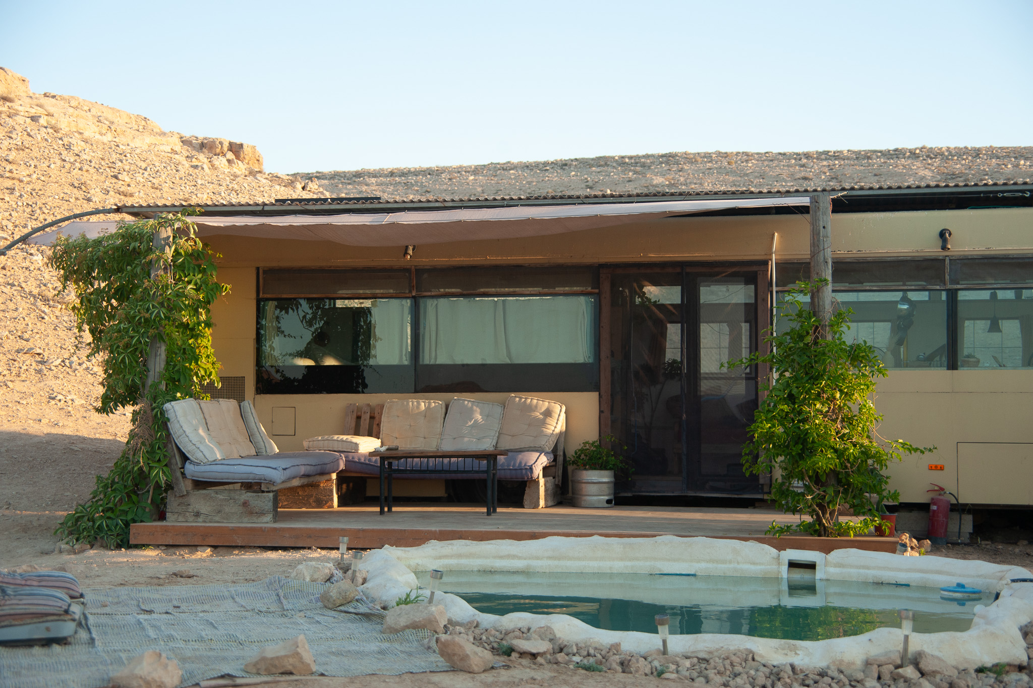 פינת ישיבה ודק עץ מחוץ לאוטובוס